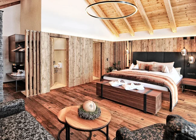 Der Salnerhof – das Hotel in Ischgl Gemütliches Hotelzimmer mit Holzboden, Doppelbett und Sitzbereich