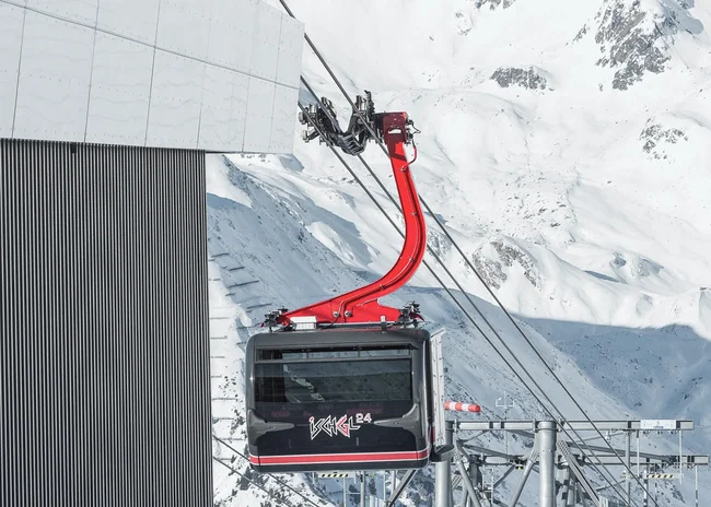 Der Salnerhof – das Hotel in Ischgl Schwarze Seilbahn mit rotem Arm an einer Bergstation im Schnee